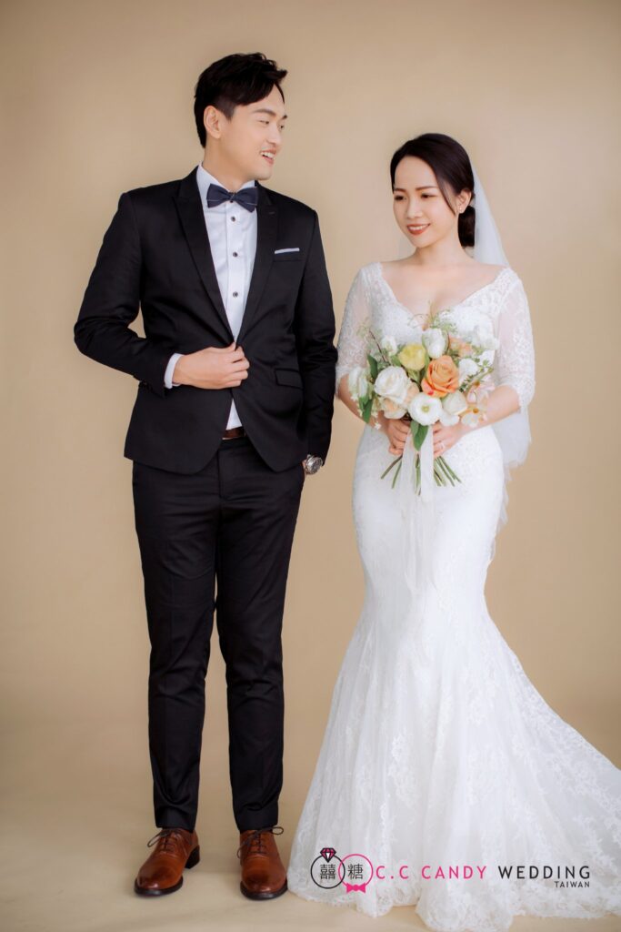 婚紗照姿勢・米色棚景中並肩 米色棚景中並肩的新人,新娘手捧花束|婚紗照推薦
