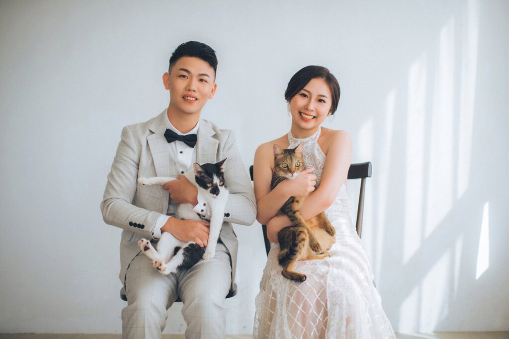抱著小狗的新人坐在棚景中｜新竹婚紗照價格
