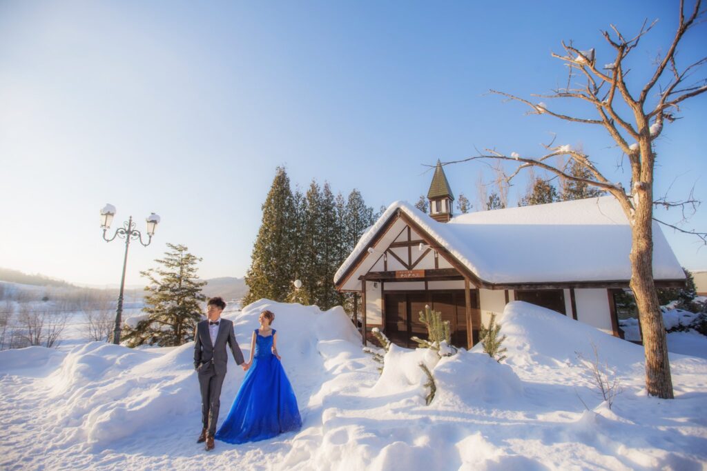 北海道婚紗・雪地木屋前 雪地木屋前的新人,新娘穿藍色禮服|沖繩海邊婚紗照