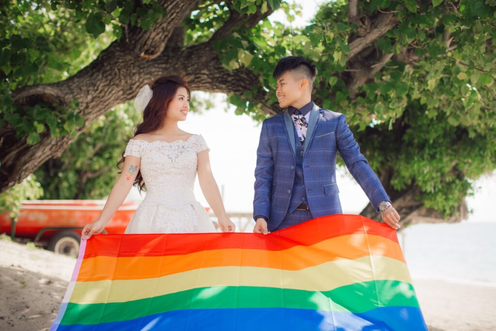 大樹下手拿彩虹旗的新人｜沖繩拍婚紗費用
