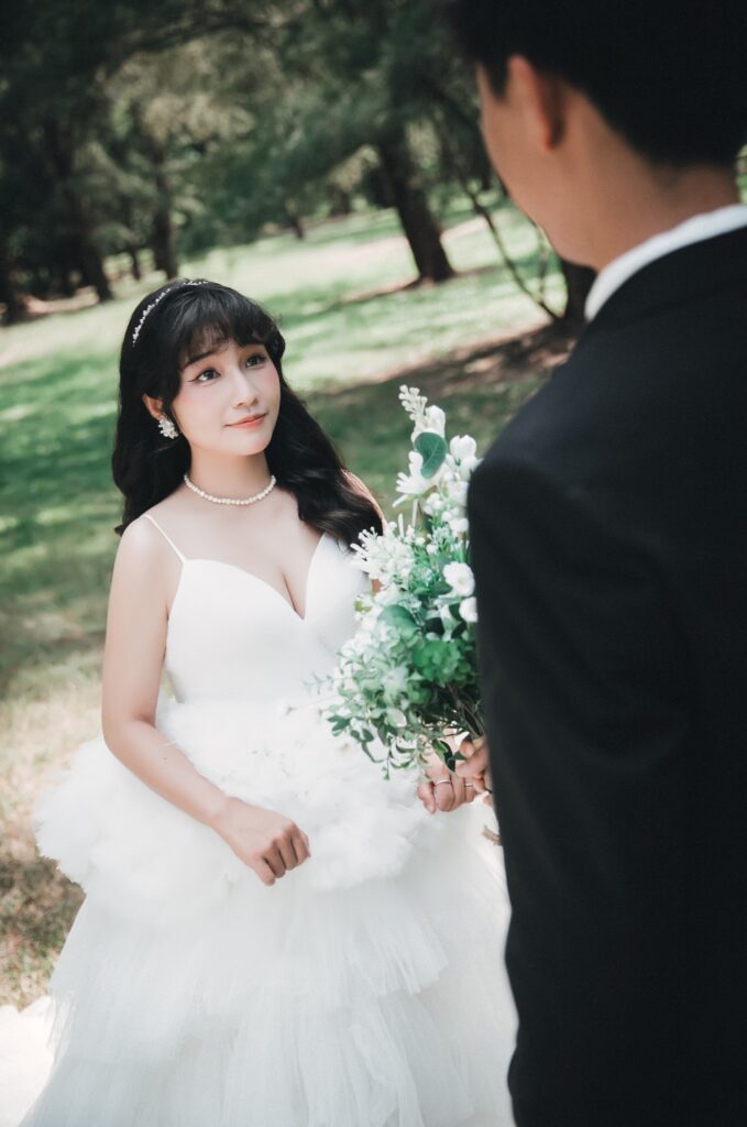 婚紗照姿勢・草地上新娘望向新郎 草地上新娘望向新郎,手捧白色花束|婚紗照推薦