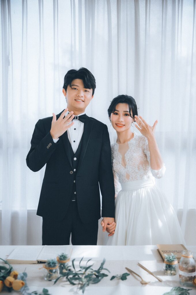 白色窗簾棚景中新人手比愛心｜婚紗照風格