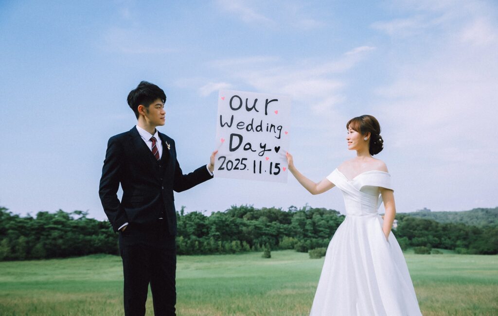 綠地上手舉婚禮日期字卡的新人｜婚紗展攻略