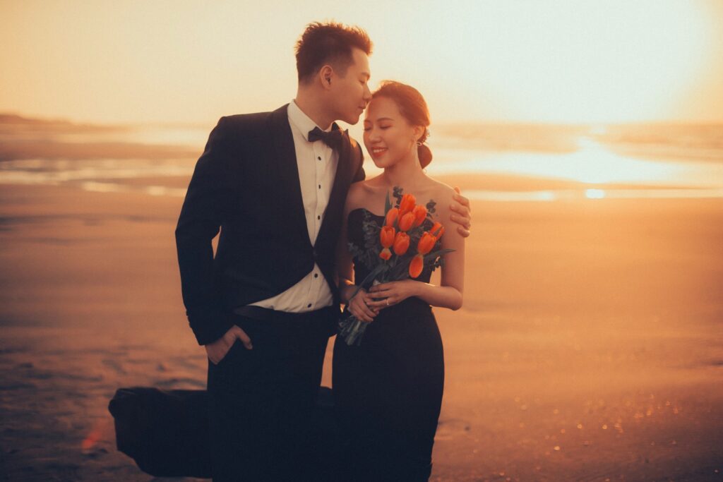 夕陽海邊新郎親吻新娘額頭｜婚紗照姿勢