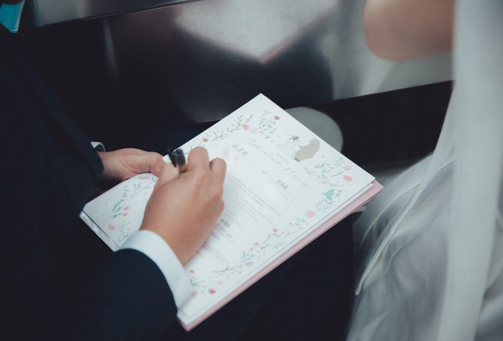 新人簽寫結婚書約的手部特寫｜登記照