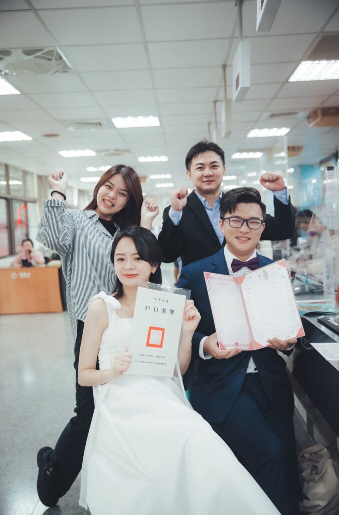 新人與親友拿著結婚書約開心合影｜登記結婚拍照