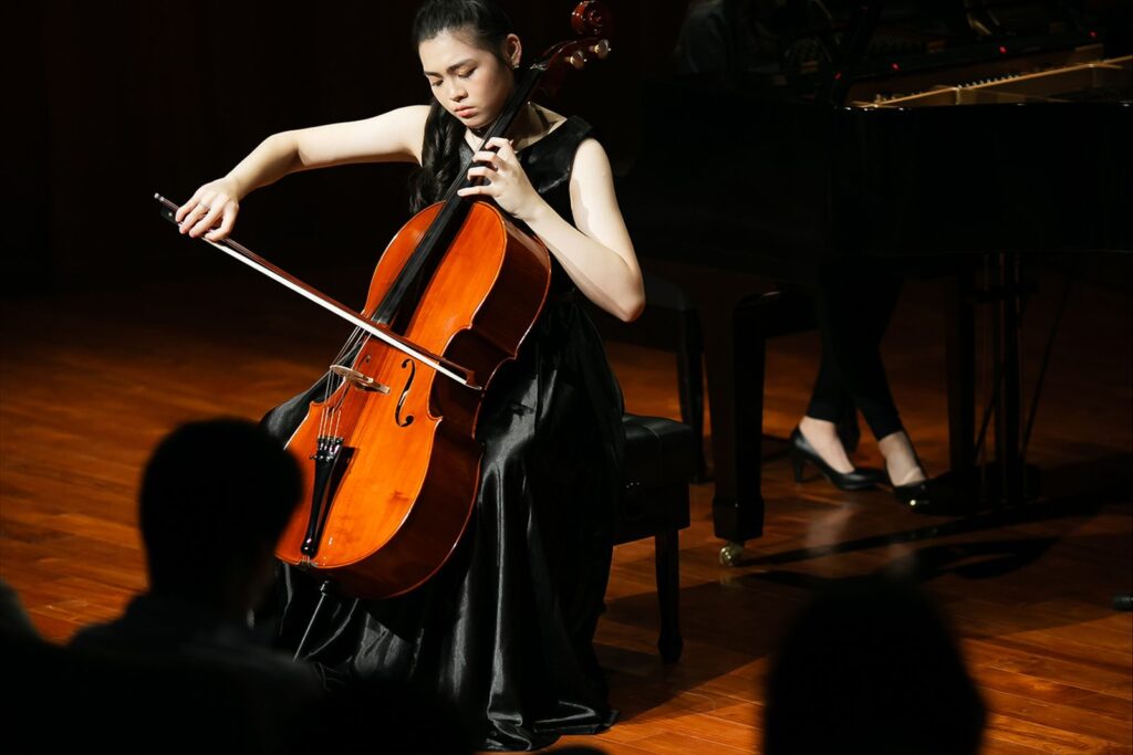 音樂會攝影:專注神情 穿黑色禮服的大提琴演奏者低頭專注演奏
