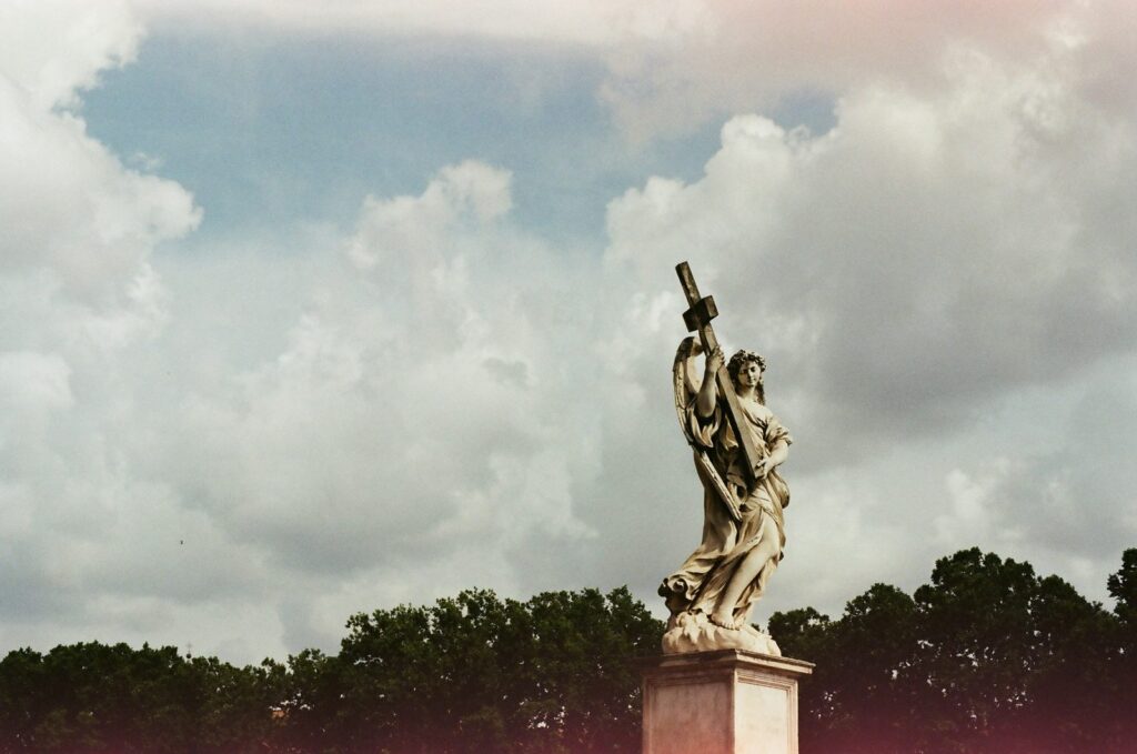底片旅拍:天使雕像與雲 底片旅拍:雲層前手持十字架的天使雕像