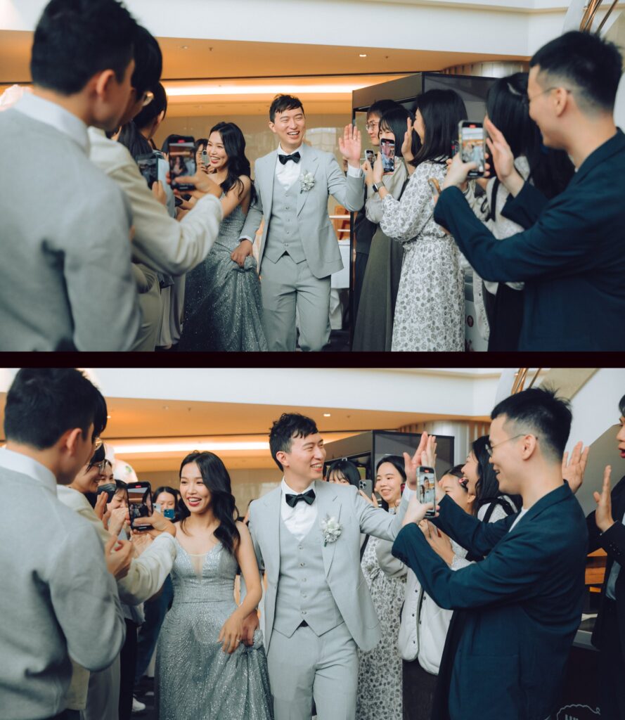 婚宴進場時穿銀灰亮片禮服的新娘與淺灰西裝新郎，和賓客擊掌歡呼