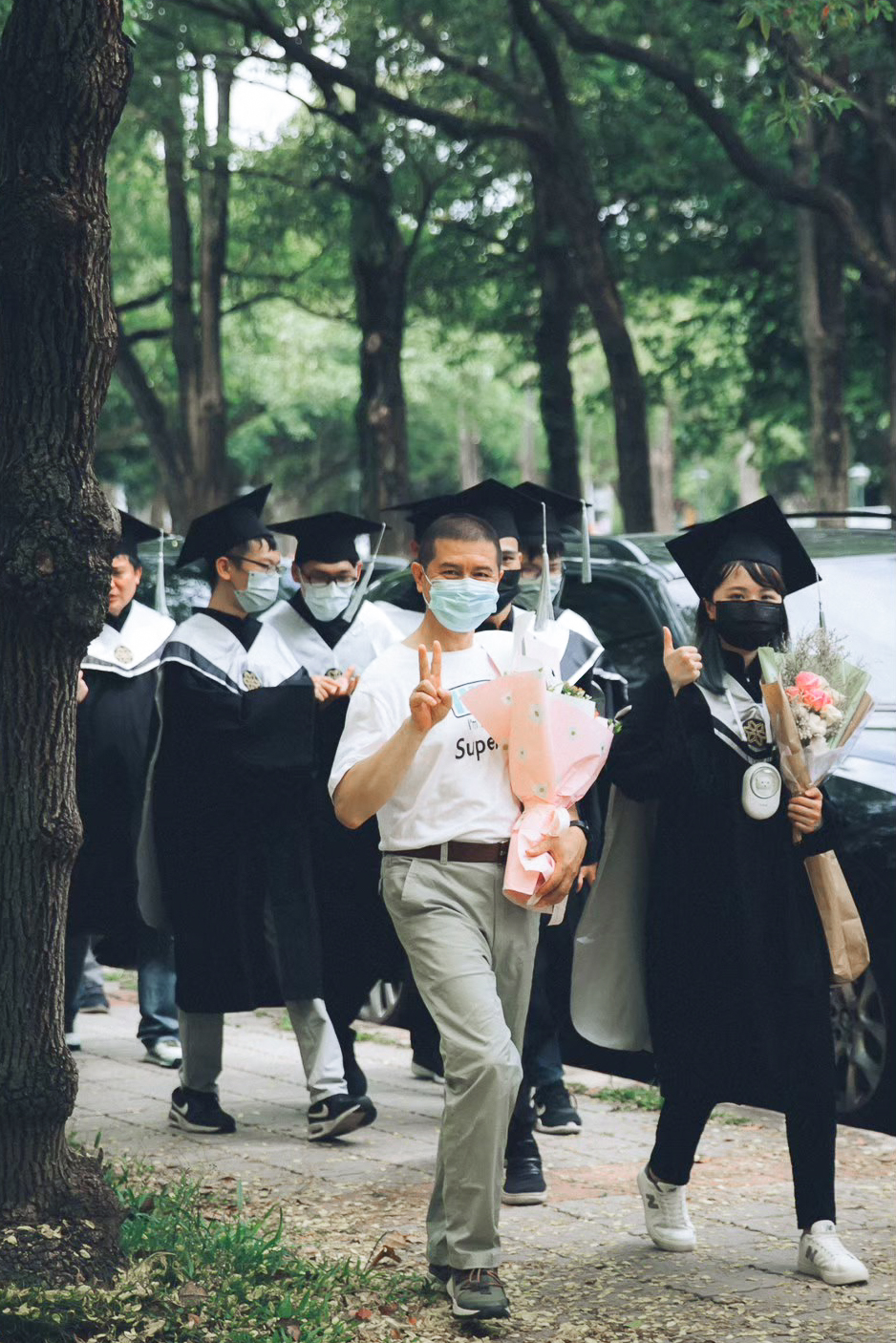 畢業典禮當天紀錄:校園林蔭道 畢業典禮當天紀錄:學士服畢業生與爸爸走在校園林蔭道