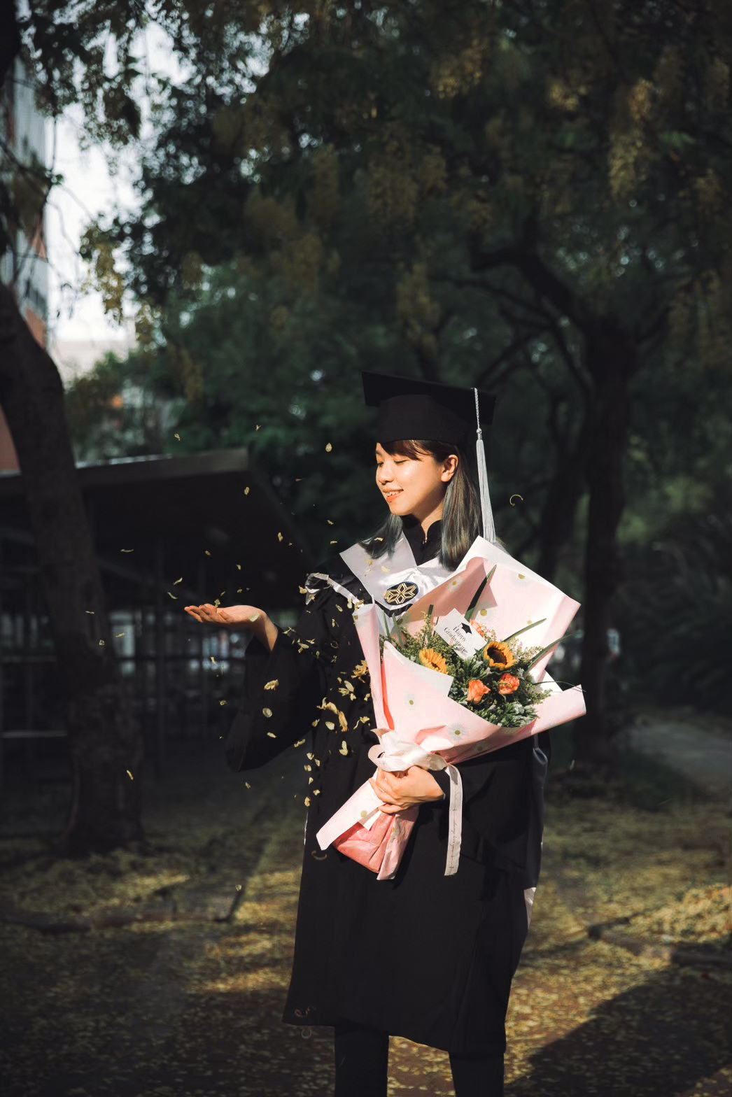 學士服畢業照:花瓣飄落 畢業照學士服人像:手捧花束、阿勃勒花瓣飄落的校園