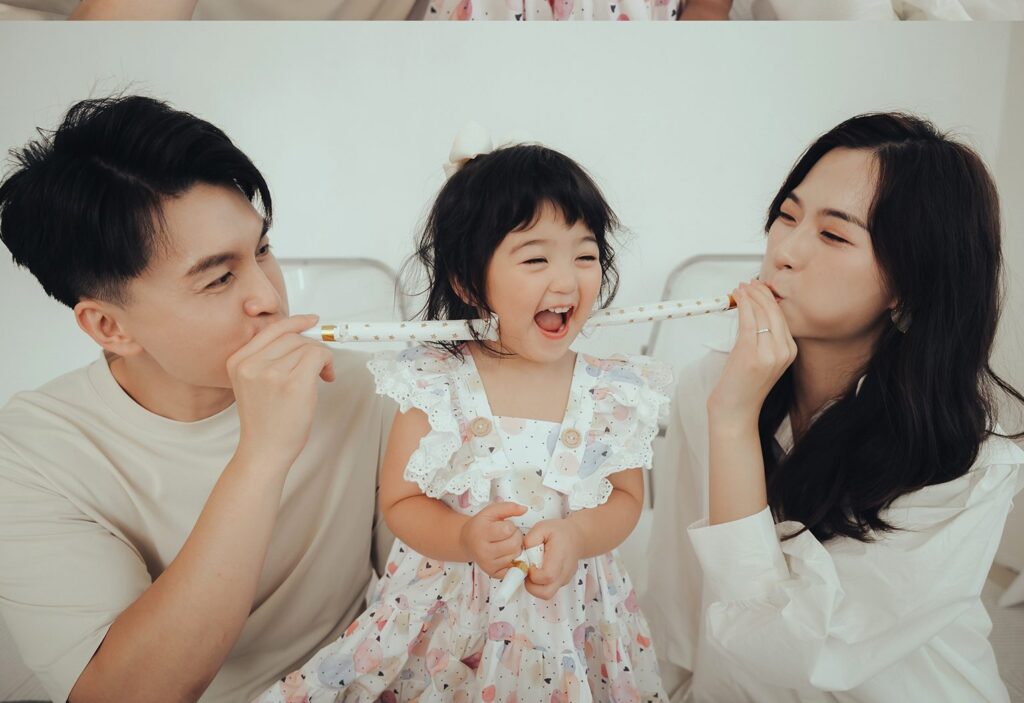 生日全家福|派對吹笛 爸媽一起吹派對吹笛,中間的女兒笑得瞇起眼睛