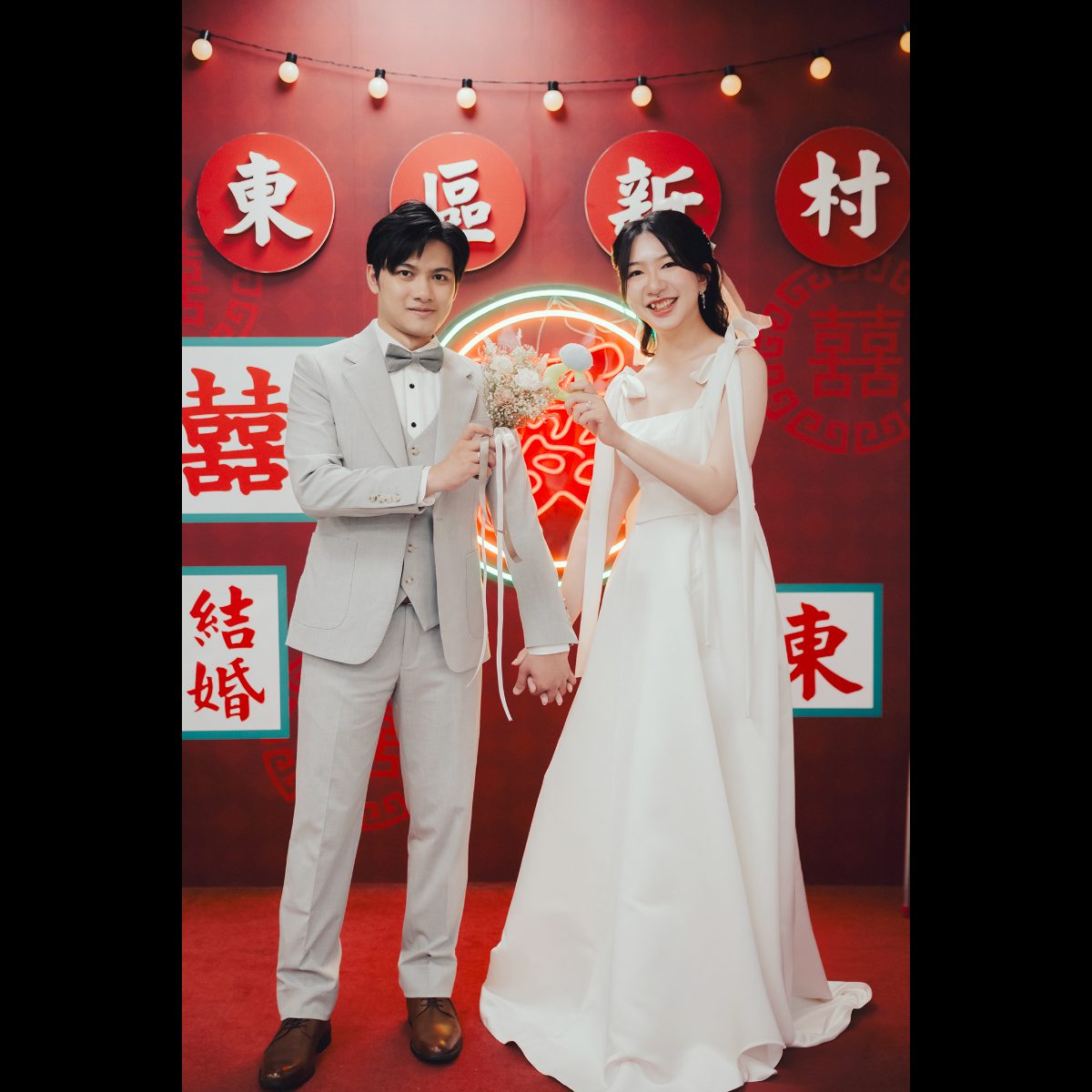新竹戶政事務所背板|東區新村背板牽手合照 新竹戶政事務所背板,新人牽手站在東區戶政紅色「東區新村」背板與霓虹愛字前