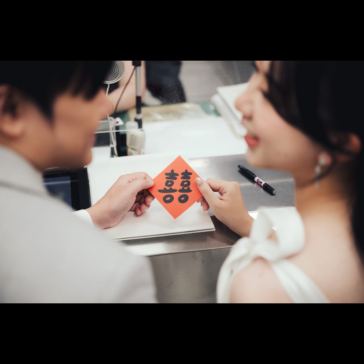 結婚登記拍照|兩人一起拿著囍字 結婚登記拍照特寫,新郎新娘在戶政櫃台一起拿著紅色囍字