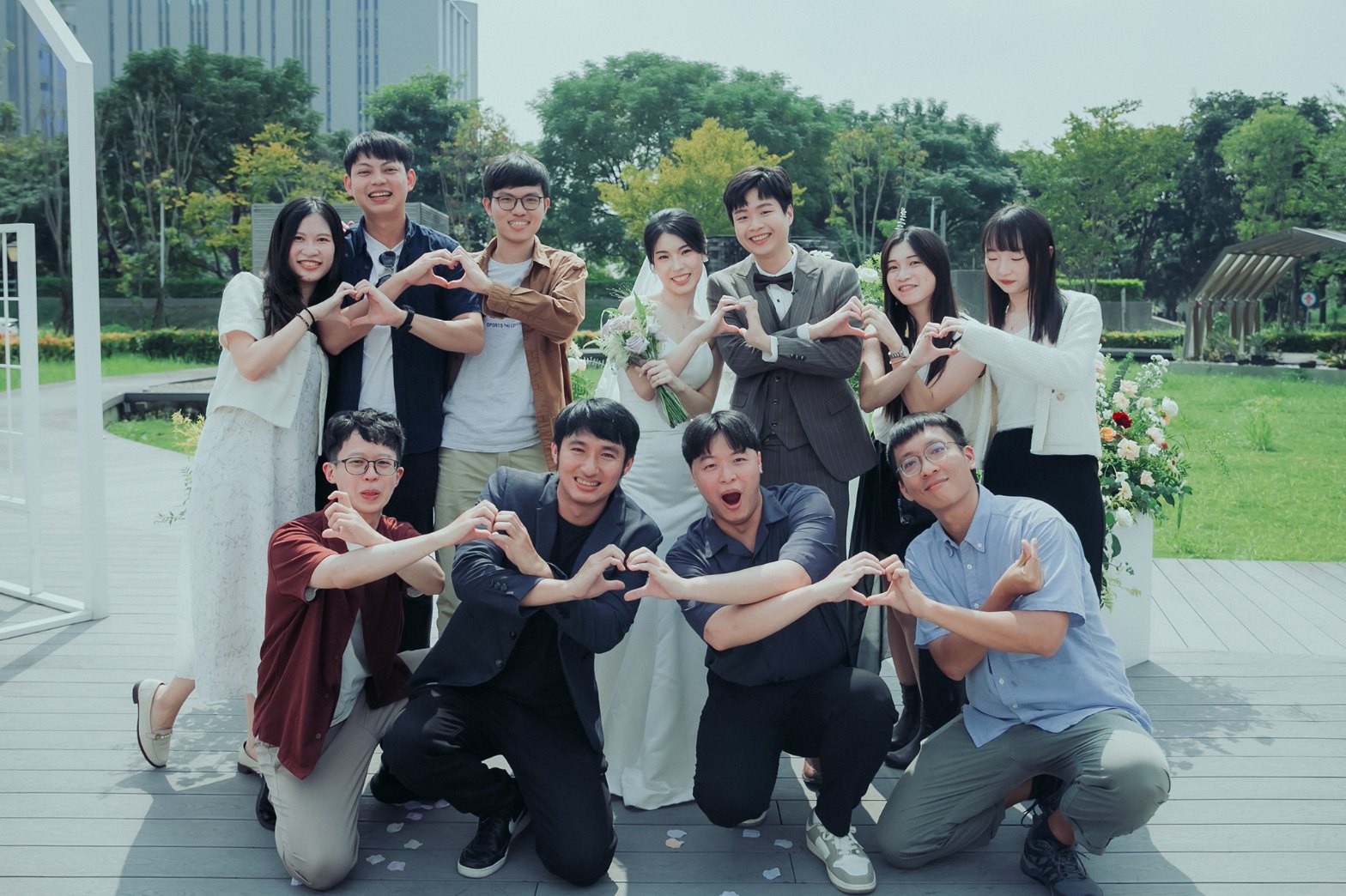 婚禮大合照比愛心：新人與朋友前後排雙手比愛心，表情豐富