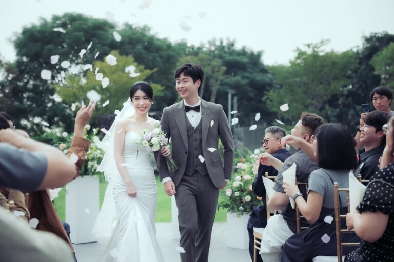 戶外證婚撒花瓣：新人手捧花束並肩走，白色花瓣在身旁飄落